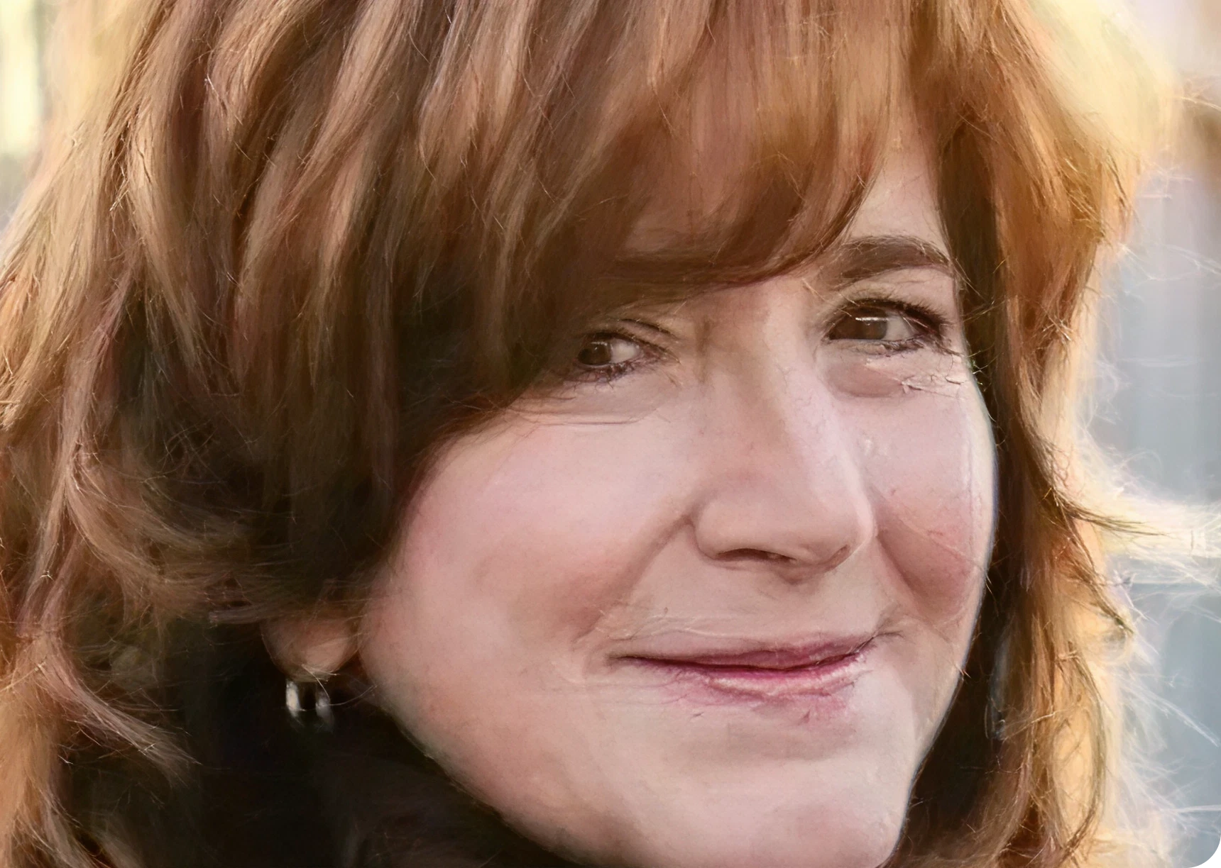 Woman with soft smile and earrings.